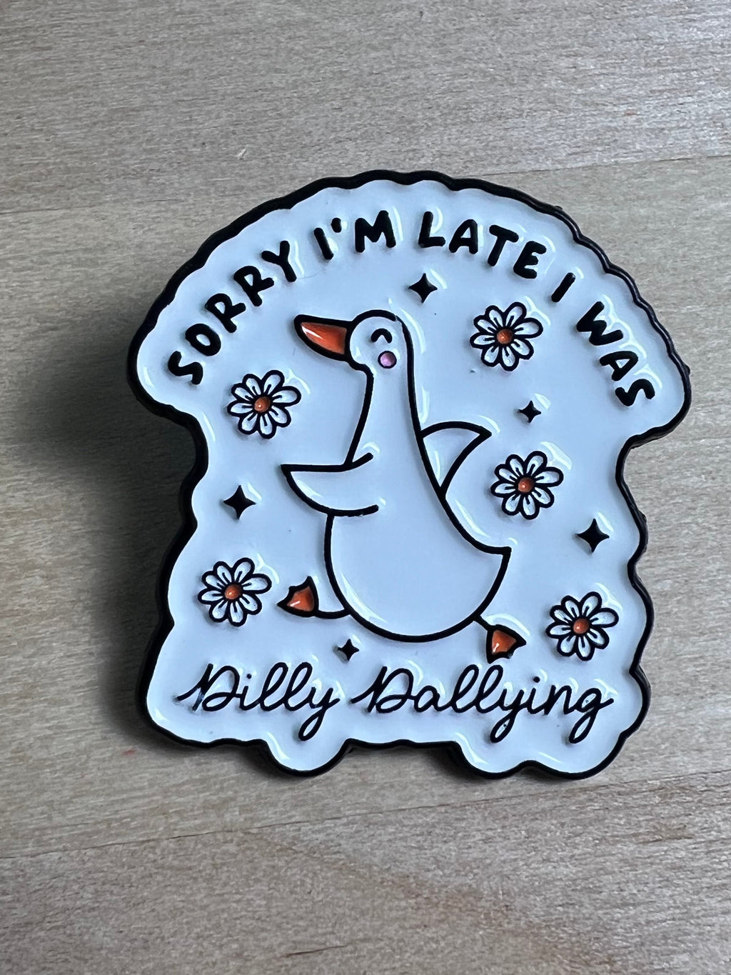Circular badge with a duck illustration and text on a wooden surface