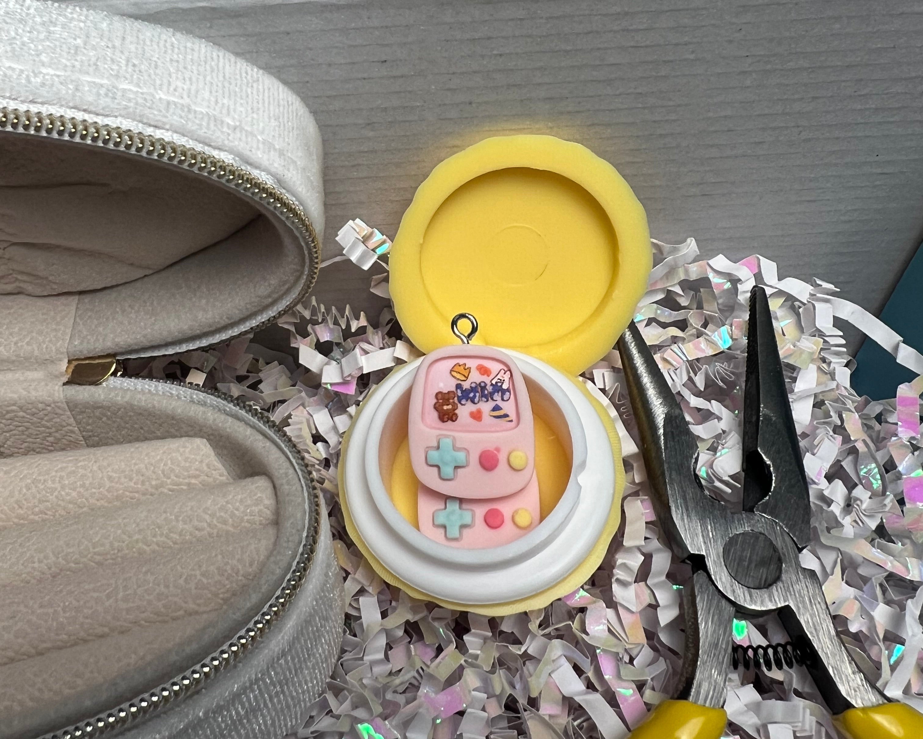 Small pink and white container with a yellow lid on a gray surface with tools and confetti.